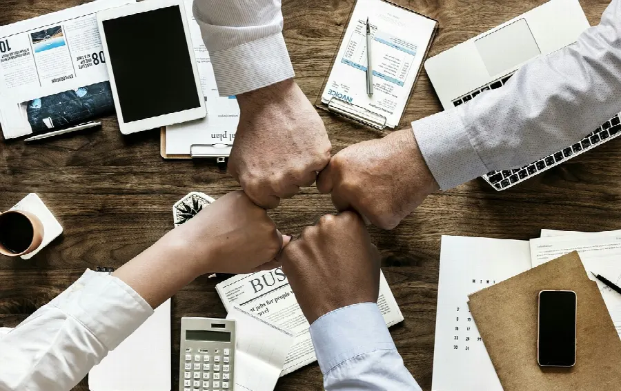 Equipe de agência reunida em escritório discutindo projeto